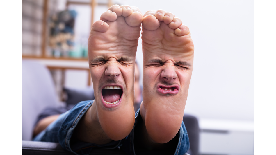 A man holds his bare feet up to show two smaller versions of his face (one on each foot)  making expressions of disgust, like something stinks