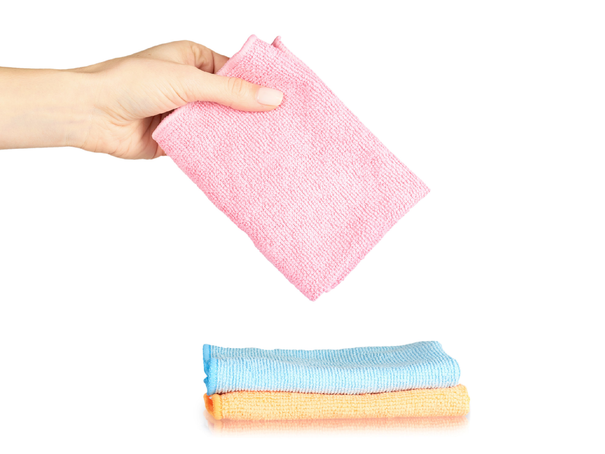 A hand holds a microfiber towel over a pile of 2 folded microfiber towels 