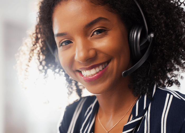 Smiling customer service representative with a headset, providing support and assistance over the phone.